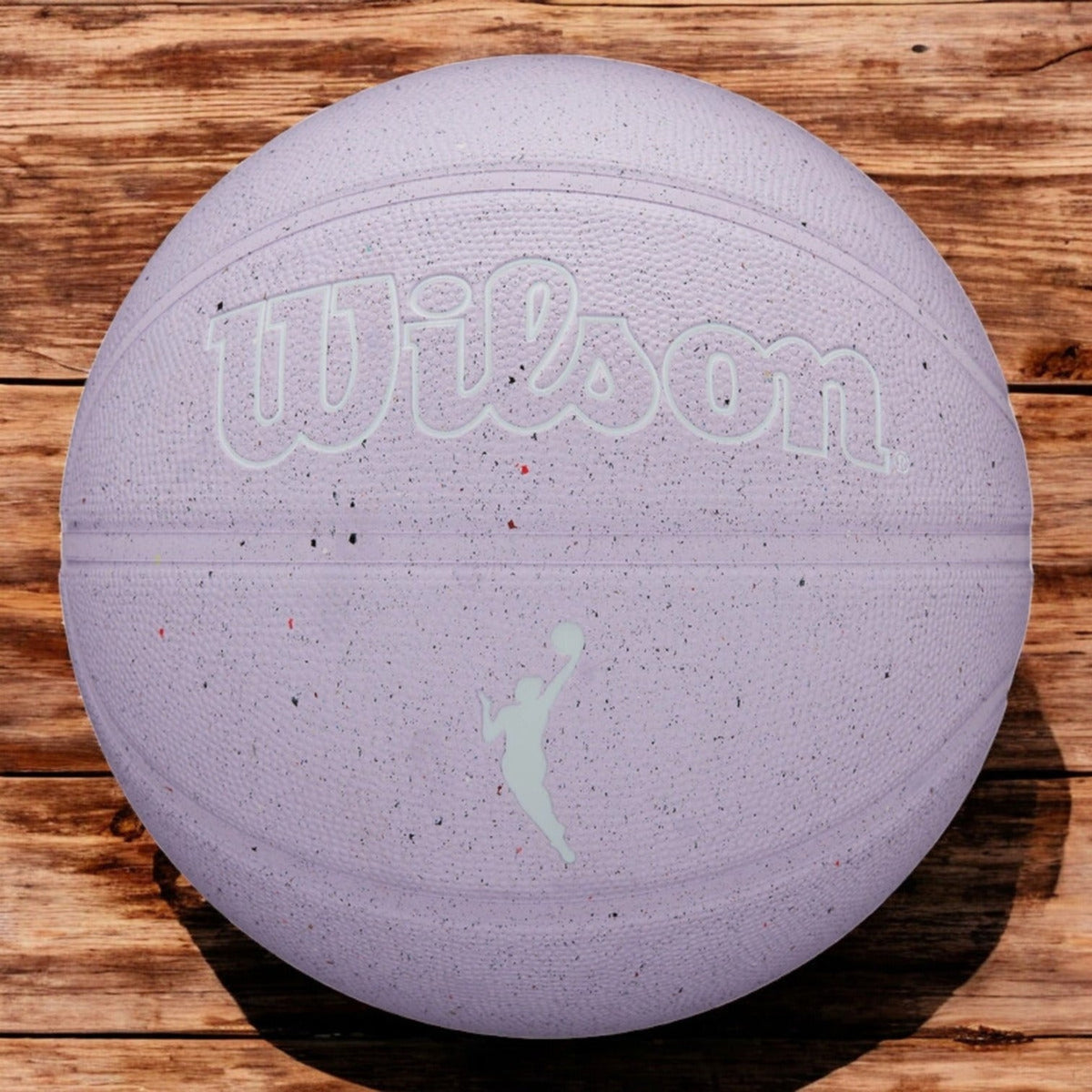 Balón de básquetbol Radach Sports Wilson WNBA Heir Eco #6 color lavanda con textura moteada sobre superficie de madera