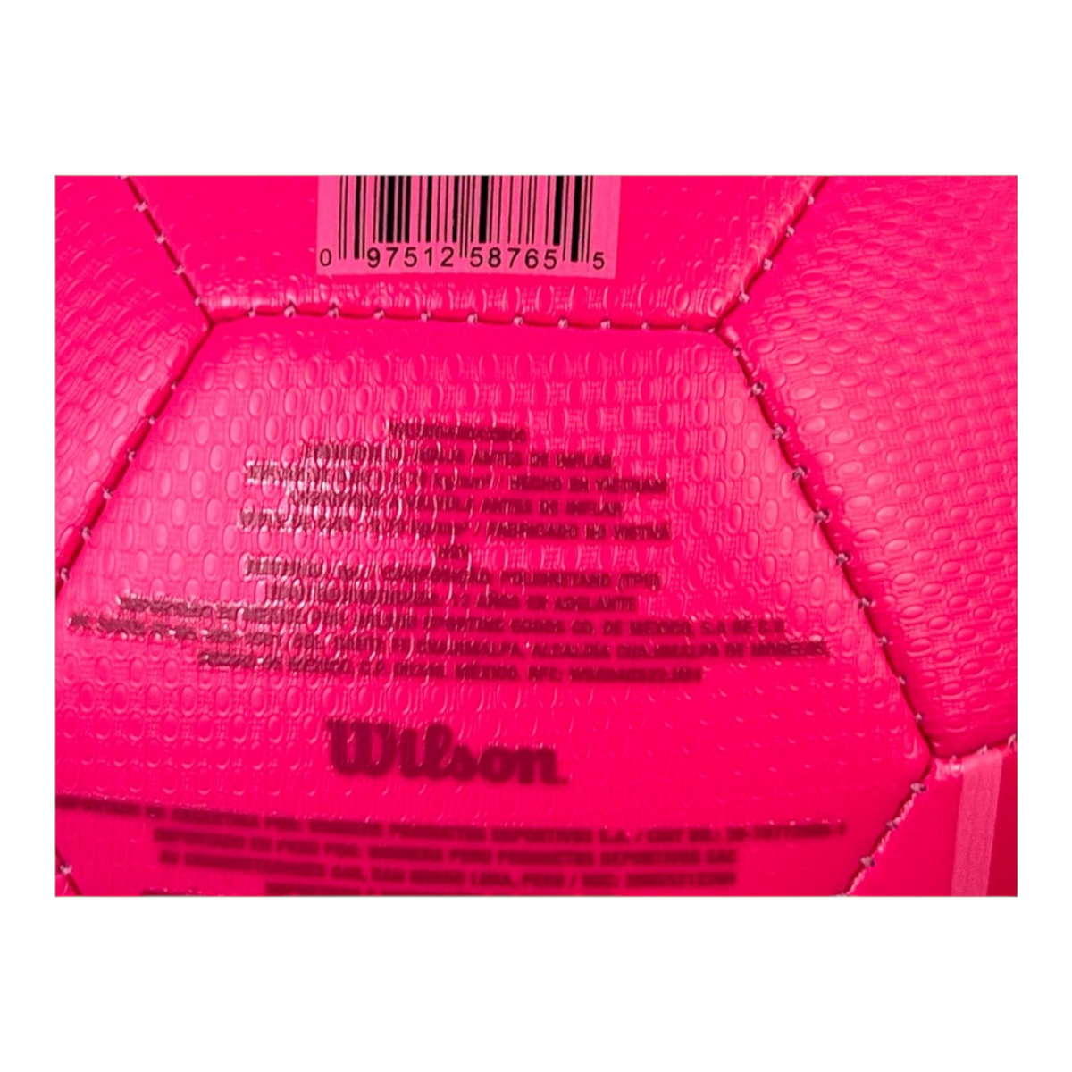 Detalle de la superficie rosa texturizada del balón de futbol Radach Sports Wilson Vantage con logo y etiquetas