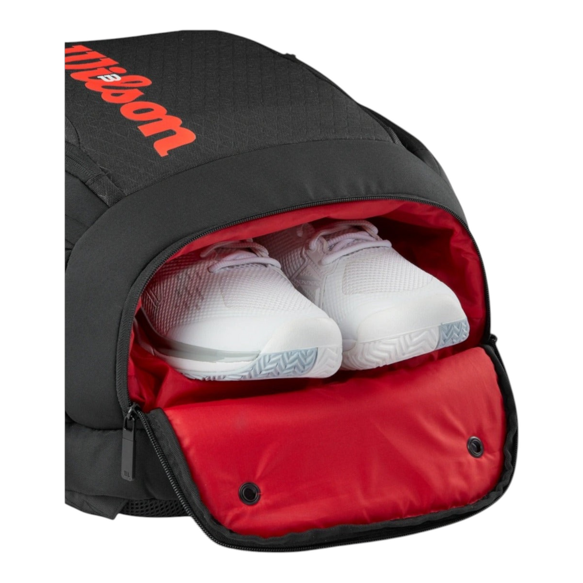 Mochila Radach Sports Wilson Clash V3 negra y roja con bolsillo ventilado abierto mostrando zapatillas de tenis