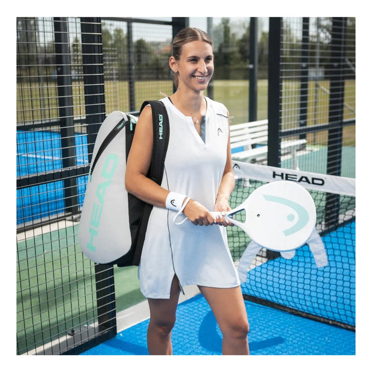 Jugadora de padel con paletero Radach Sports Head Tour gris y blanco y pala a juego en una pista de padel