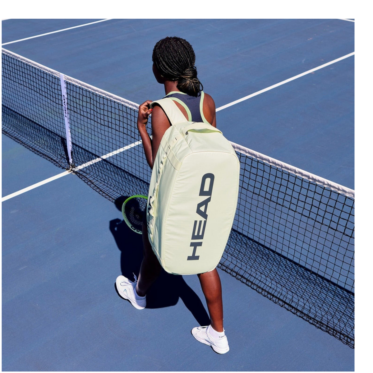 Jugadora de tenis con raquetero Head Pro Duffle Bag L de Radach Sports en color verde claro en una pista azul