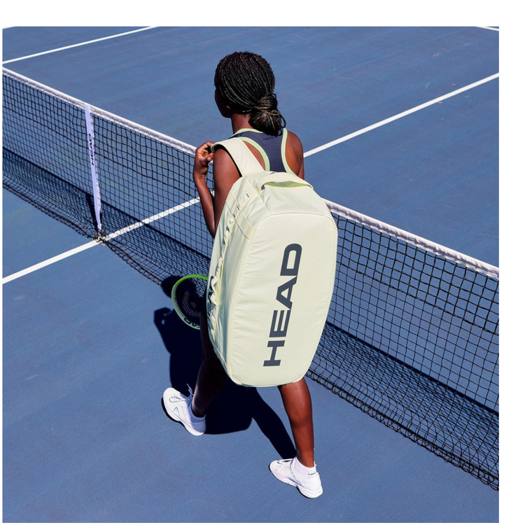 Jugadora de tenis con raquetero Head Pro Duffle Bag L de Radach Sports en color verde claro en una pista azul