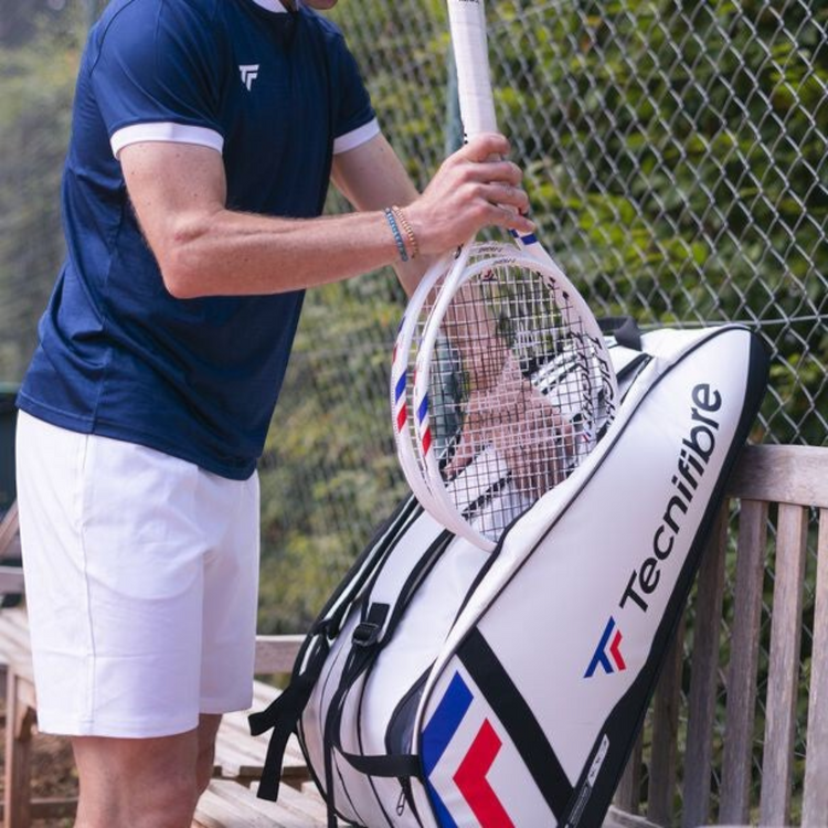 Raquetero Radach Sports Tecnifibre Tour Endurance 12R blanco con detalles en azul y rojo sobre un banco de madera